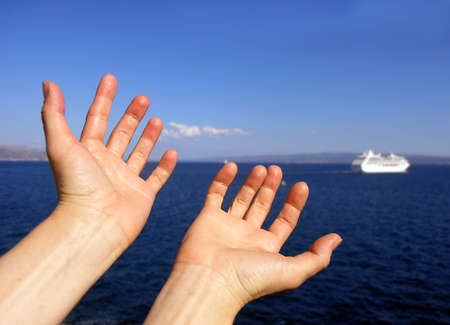 Two opened hands on blue sky and the sea     の写真素材