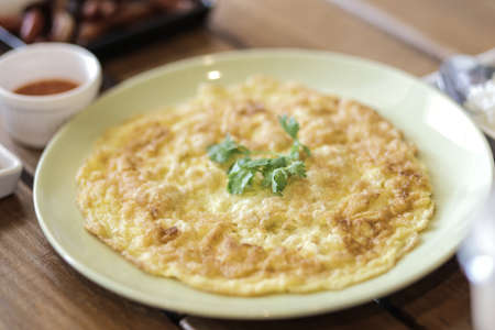 Omelette in green dish on wood table