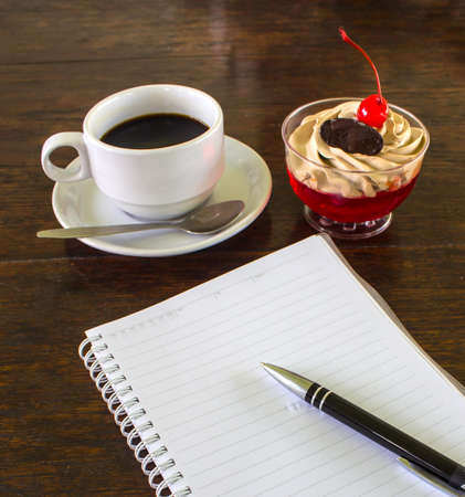 A delicious cake with a coffee and the pocketbook.