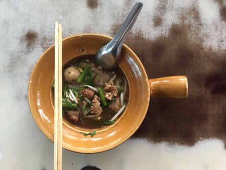Thai style pork noodle soup in a vintage bowl.