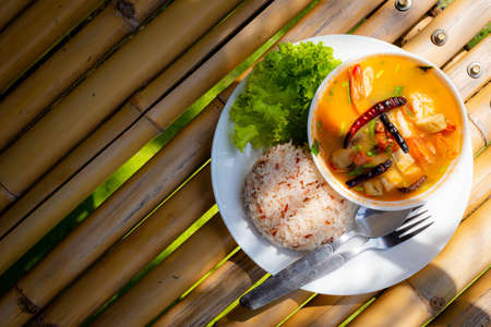 Tom Yum Goong, Prawn in Spicy Sour Soup with Brown rice on white dish - Thai food styleの写真素材
