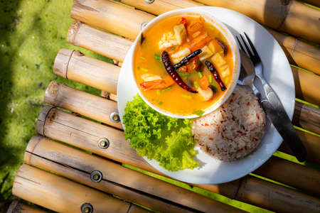 Tom Yum Goong, Prawn in Spicy Sour Soup with Brown rice on white dish - Thai food styleの写真素材