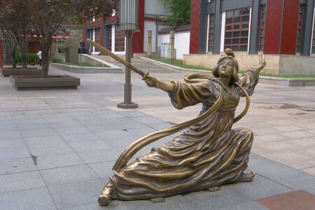 Metal copper statue of woman holding sword posing Chinese Kung Fu posture in ancient traditional dress. Dayan Pagoda, Xian Chinaのeditorial素材
