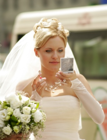 Bride checking her face using the mirrorの写真素材