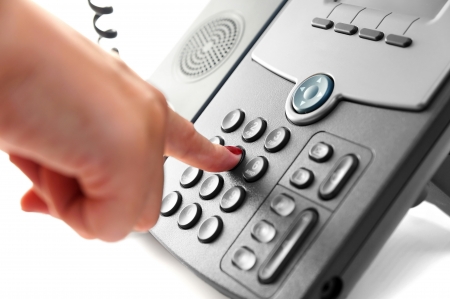 woman hand is dialing a phone number with picked up headsetの写真素材