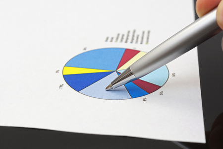 businessman is analyzing financial report on pie chart