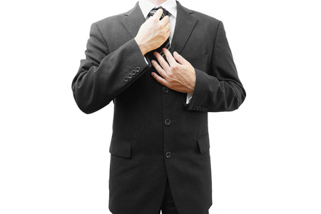 Businessman adjusting his tie, isolated on whiteの写真素材