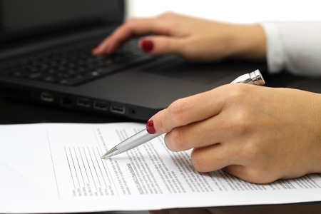close up of female business hands working on  document and laptopの写真素材