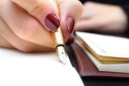 Woman is writing in notepadの写真素材