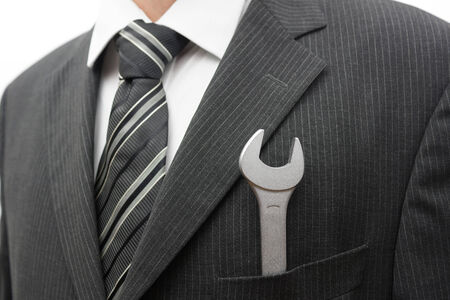Businessman with spanner in suit pocketの写真素材