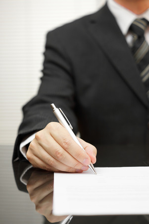 businessman is signing documentの写真素材
