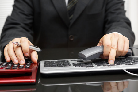 consultant is working on computer and calling clientの写真素材