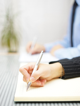 Business people writing notes  sitting in the officeの写真素材