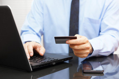 Businessman is using credit card for on line payment on laptopの写真素材