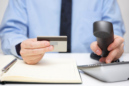 businessman with credit card dialing phone for  supportの写真素材