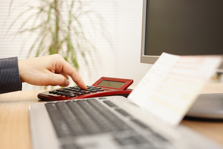 Man is calculating how much money he need to pay the billsの写真素材