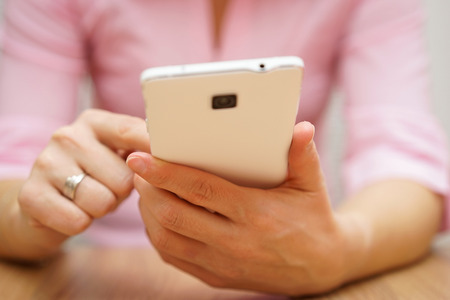 woman is typing on touch screen on mobile phoneの写真素材