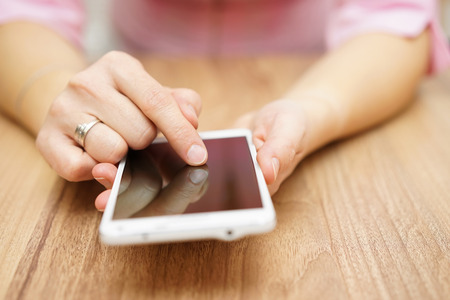 Young woman is using big white smart  mobile phoneの写真素材
