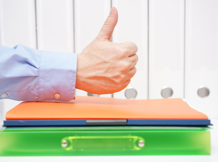 a good accountant concept. thumbs up over bindersの写真素材