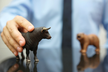 businessman holding bull, concept of bullish trend on stock marketの写真素材