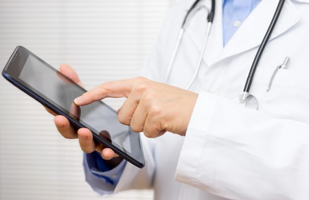 doctor in office working tablet computerの写真素材
