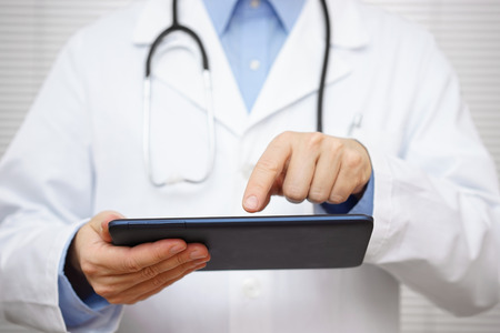 doctor is checking diagnose result on tablet computerの写真素材