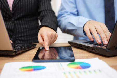 business people are working together on financial project using laptop and  tablet computerの写真素材