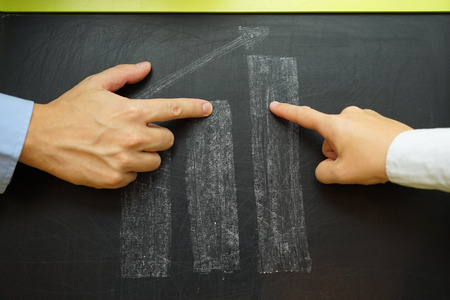 business people discussing about business growth, growing graph on blackboardの写真素材