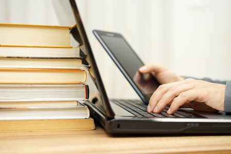 Student is using tablet pc , laptop computer and courseware at the same timeの写真素材