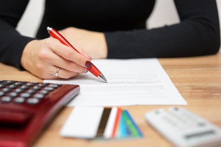 woman is reading bank notice about credit card spending and  repayment of debtの写真素材
