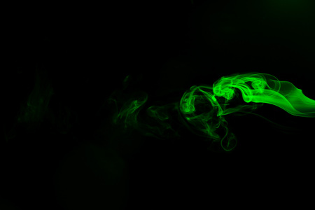 Green coloured smoke abstract lighting on a black backgroundの写真素材