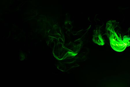 Green coloured smoke abstract lighting on a black backgroundの写真素材