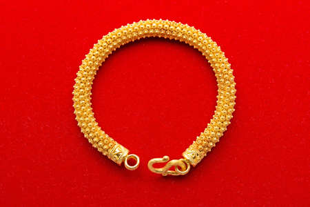 Ornament Golden Bracelet Isolated on Red Backgroundの写真素材