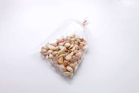 Garlic in Plastic Clear Bags Isolated on White Backgroundの写真素材