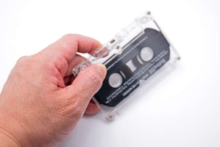Hand Holding Blurry Cassette Tape Isolated on White Backgroundの写真素材