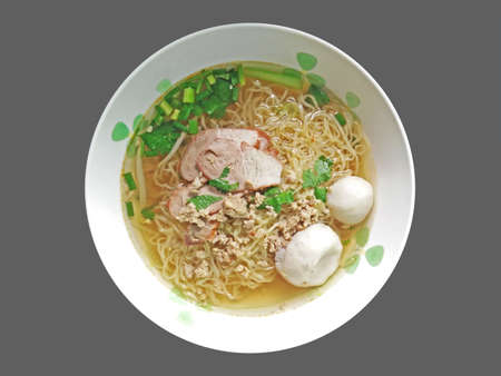 Egg Noodle Soup with Red Roast Pork and Fish Balls on Gray Background