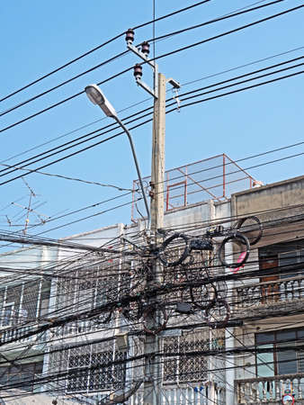 Disarrangement of Electric Wire on Pole near Buildingの写真素材