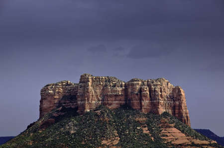 Dark gray sky over sunlit rocks near Sedona in Arizona