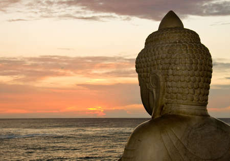 Side view of Buddha overlooking the setting sunの写真素材