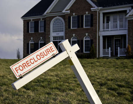 Modern house with crooked foreclosure sign in suburbsの写真素材