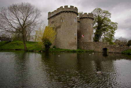 Reflection of Whittington Castle in the moat with ducks swimming byの写真素材