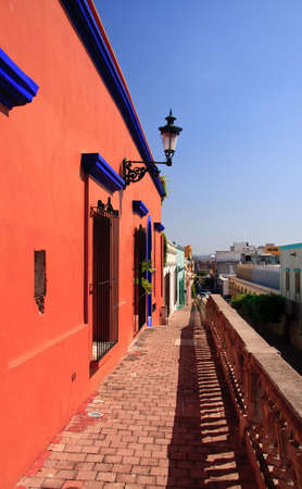 Elevated brick walkway with a bright orange house on the left hand sideの写真素材