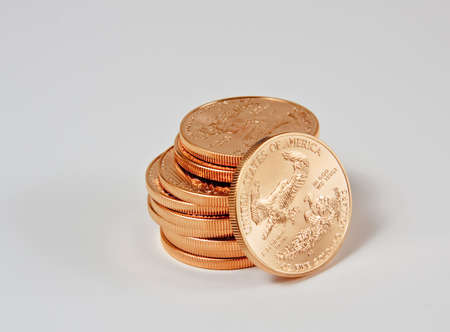 1 Ounce gold eagle coins in a stack with one coin looseの写真素材