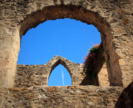 View of an old arch in San Juan Mission in Texas with modern jet trail in skyの写真素材