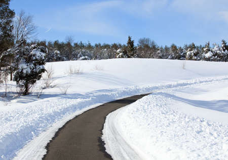 High snow banks by side of road leading up a hill after recent plowingの写真素材