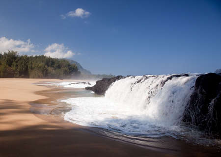 Strong waves crash over rocks on the beach at Lumahai on Kauaiの写真素材
