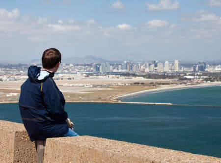Skyline of San Diego in background behind Cabrillo monument on Point Loma with man overlooking the viewの写真素材