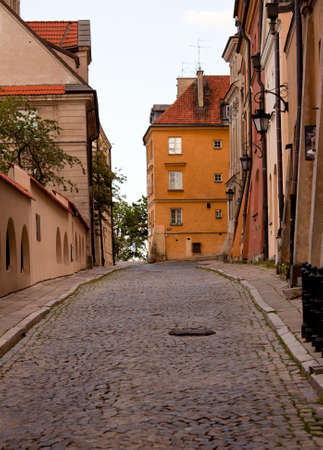 Old ornate lanterns in front of the orange facades of old buildings in Warsaw Polandの写真素材