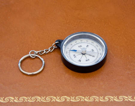 Compass laying on old leather desk with gold ornate edgingの写真素材
