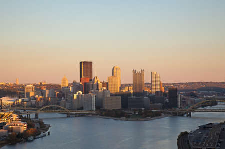 Setting sun highlights the tops of the tall buildings in downtown Pittsburghの写真素材